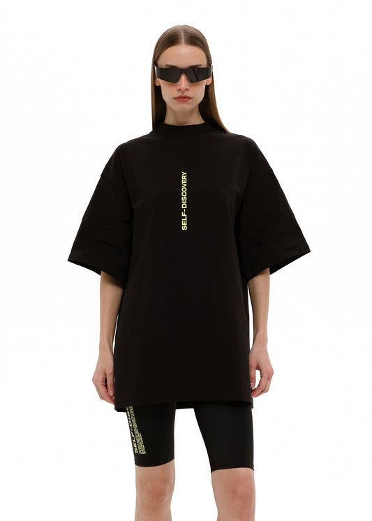 Remera oversize negra con texto vertical SELF DISCOVERY en amarillo flúo